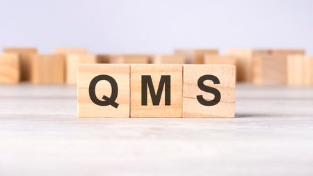 QMS - acronym concept written on wooden cubes or blocks on a light gray backgroundの写真素材