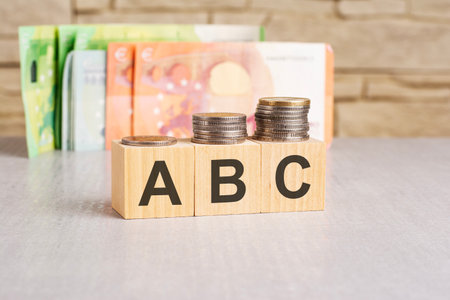 business concept. On a gray surface, dollars and wooden blocks with the inscription - ABC - short for Always Be Closingの写真素材