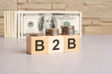 B2B word on wooden cubes and US dollar bills background. business to business conceptの写真素材