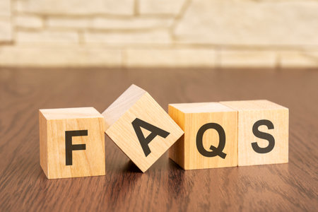 wooden blocks with word FAQ on brown background. frequently asked question concept