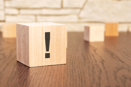wooden blocks with exclamation mark on wooden table, close up. space for textの写真素材