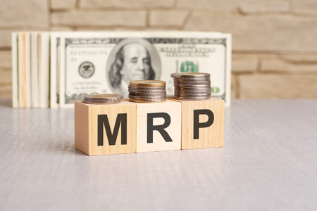 MRP word on wooden cubes and US dollar bills background. marketing research planning conceptの写真素材