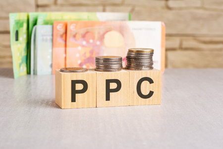 business concept. On a gray surface, banknotes euro and wooden blocks with the inscription - PPC - short for Pay Per Clickの写真素材