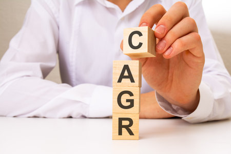 wooden cubes with the word CAGR, the hand puts a cube with letter C, business conceptの写真素材