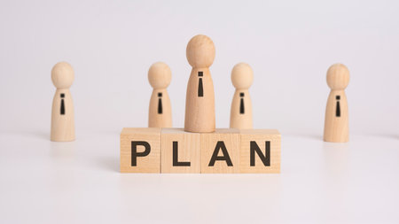 text plan written on wooden dice lying on a table with wooden manの写真素材