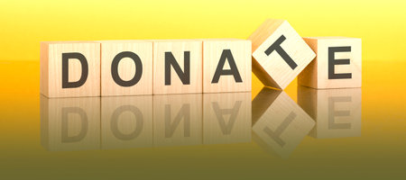 text donate on wooden blocks, yellow backgroundの写真素材