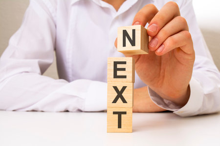 man made text NEXT with wood cubes on the background of the office table. selective focus. business conceptの写真素材