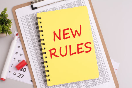 text 'NEW RULES' written on a yellow sheet of paper with a red marker, captured from a top view. concept concept suggests a shift or update in regulations, guidelines, or proceduresの写真素材