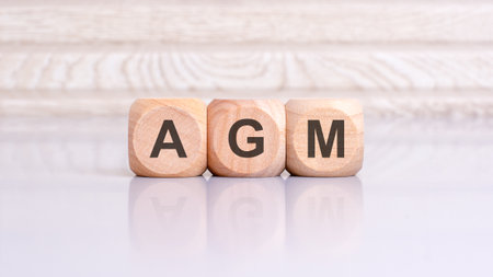 AGM sign on the gray table with wooden background. AGM - short for Annual General Meeting.の写真素材