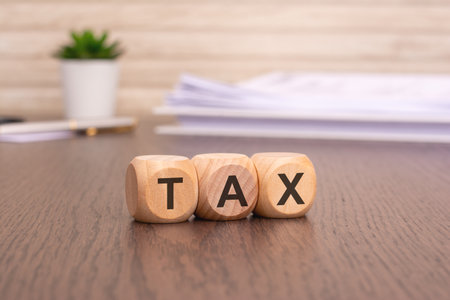 text TAX on wooden cubes over blur background with copy space, financial concept backgroundの写真素材