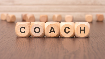 the text COACH is written on wooden blocks on a light backgroundの写真素材