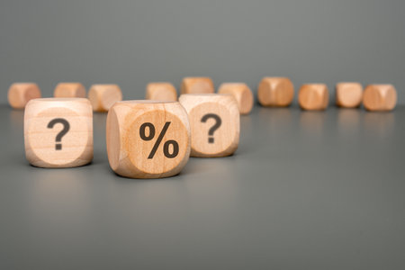 Wooden blocks featuring unique symbols that represent inquiries, percentages, and ideas, exploring financial conceptsの写真素材