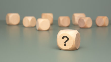Intriguing Wooden Blocks That Are Beautifully Displaying Question Marks on a Gray Surfaceの写真素材