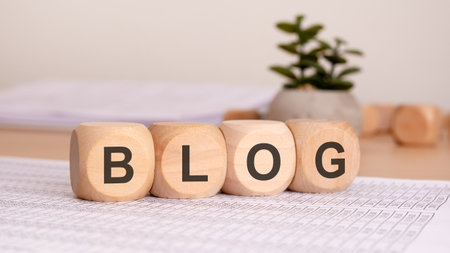 Stylish wooden blocks creatively arranged to spell out BLOG on a modern workspace, showcasing...