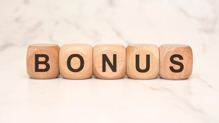 wooden blocks spelling BONUS on a marble surface, symbolizing rewards and extra benefitsの写真素材