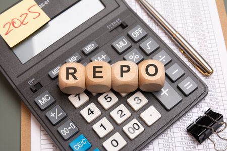 Wooden cubes spelling REPO placed on calculator keypad, surrounded by financial spreadsheet, pen, and binder clip, symbolizing finance, economics, and repo market conceptの写真素材
