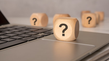 Wooden cube with question mark on laptop keyboard, close-up concept imageの写真素材