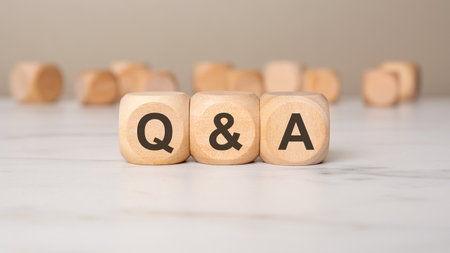 wooden blocks with the letters Q and A on a wooden surface with a dark background