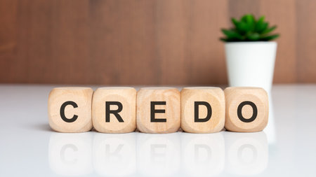 wooden cubes with word CREDO on white table and green plant in backgroundの写真素材