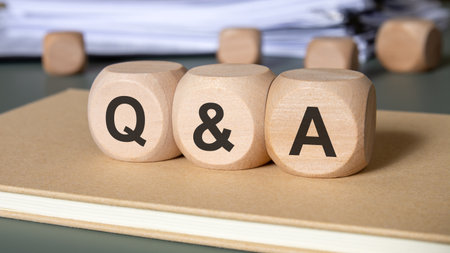 wooden cubes spelling Q and A on a notebook at a desk, evoking communication and guidance