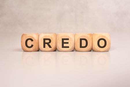 Five light wood cubes aligned to form the word CREDO lie on a neutral desk surface. The minimalist composition evokes themes of belief, guiding principles, corporate values, mission statements, and ethical direction.の写真素材