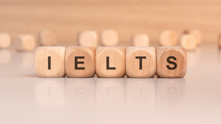 wooden cubes spelling IELTS on a clean tabletop concept of English language examの写真素材