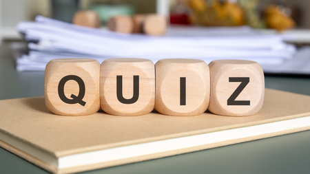 Wooden cubes spelling QUIZ on a notebook with paperwork concept of testing or examinationの写真素材