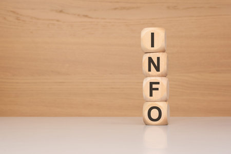 stacked wooden blocks spelling INFO on a light surface with soft neutral background