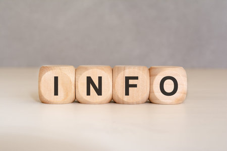 Concept of information, data, and communication. Four wooden blocks arranged horizontally to show the word INFO on a clean surface. Perfect for help desks, informative guides, and customer service content.の写真素材