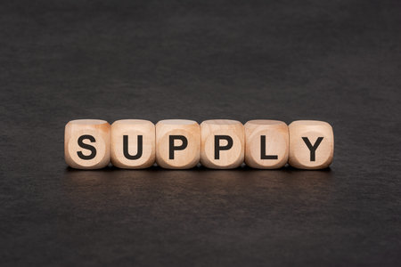 Business concept of supply chain management and economics. Wooden letter blocks forming the word...