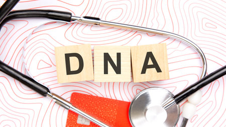 Medical finance concept of genetic testing costs. Wooden letter blocks spelling DNA arranged with a...
