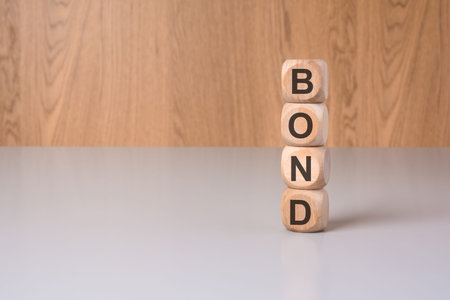 BOND word on wooden blocks stacked vertically on a desk.