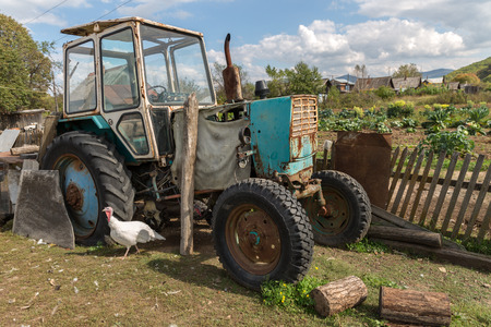 tractor stands near a fence in the villageの写真素材