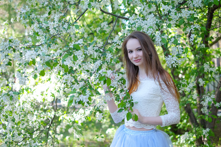 Beautiful spring girl in blooming treeの写真素材