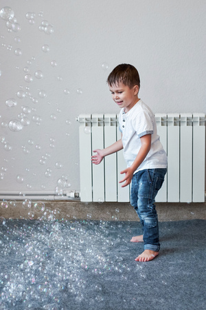 Little boy playing with many bubbles on the party and dancing, indoorの写真素材