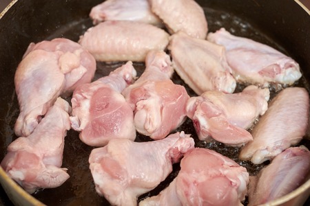 Chicken wings fried in pan with hot oil, homemade foodの写真素材