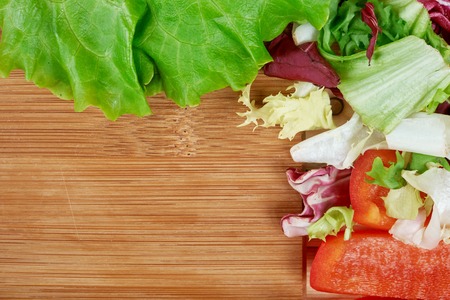 Frame of fresh organic vegetables on wooden background. Healthy natural food on table with copy space . Cooking ingredients top view, mockup for recipe or menu.の写真素材