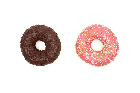 Tasty chocolate donut and Pink donut with colorful sprinkles on white backgroundの写真素材