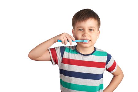 Smiling boy brushes his teeth and shows a thumbs up, isolated on a white backgroundの写真素材