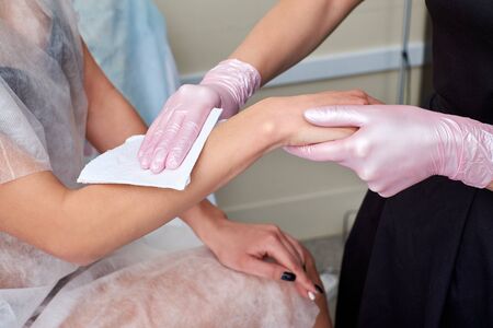 A cosmetologist checks the results of a laser hair removal procedure.の写真素材