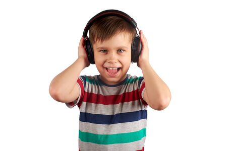 Child listens to his favorite music on headphones and dances to it , isolated on white background. Leisure, music and entertainment concept.の写真素材