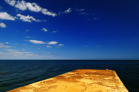 Beautiful summer landscape - concrete pier on the background of the dark blue sea on a sunny day, Crimeaの写真素材