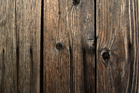 Wood texture - old dark cracked boards with knots, nailed with rusty nailsの写真素材