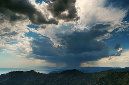 Beautiful summer landscape - cloudy sky with the cloud from which the rain over the mountains, Crimeaの写真素材