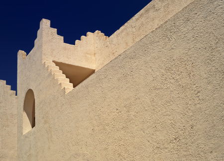 Beautiful beige building in the Oriental style, lit by the sun against the background of the dark blue skyの写真素材