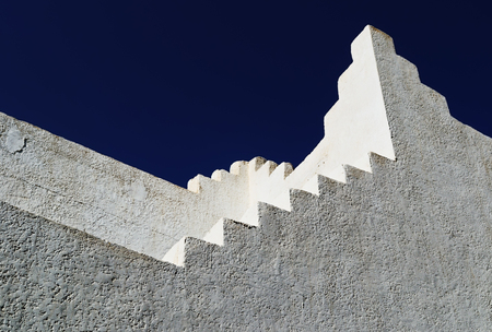 Architectural structure in white with rough walls and stairs in Oriental style on the background dark blue skyの写真素材