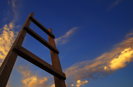 Wooden ladder, directed to the blue sky with clouds at sunsetの写真素材