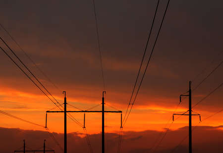 High voltage power line at sunset on a background of cloudy orange skyの写真素材