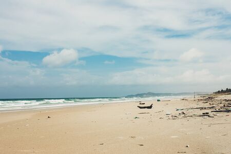 Garbage on the shore of a beautiful sea beach, environmental pollution, lots of plastic bottles, polystyrene foam, environmental problem. Waves moving ashoreの写真素材