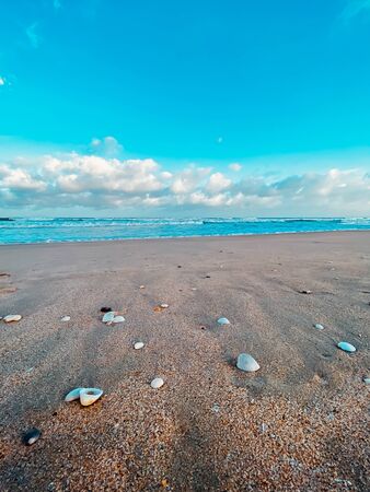 Seascape, sea view. Waves at sea, sea tide, sandy shore. Sea foam. Beautiful clouds in the blue sky....